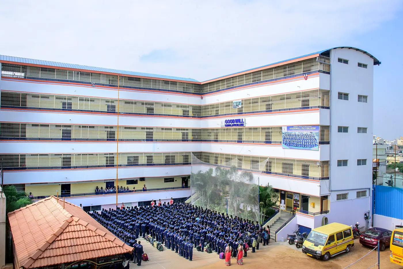 A multi-storey school building with a large assembly ground